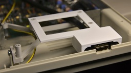 The holder frame (white) sits within the frame of the GOEX drive (grey) and does not need any screws.
